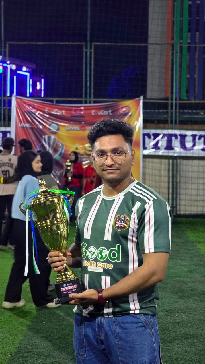 Student holding the football trophy at the ASMI Premier League